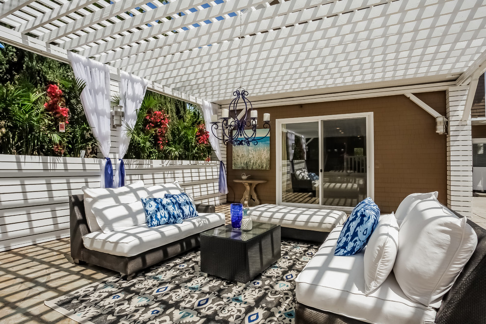 This is an example of a tropical backyard patio in Charlotte with a pergola.