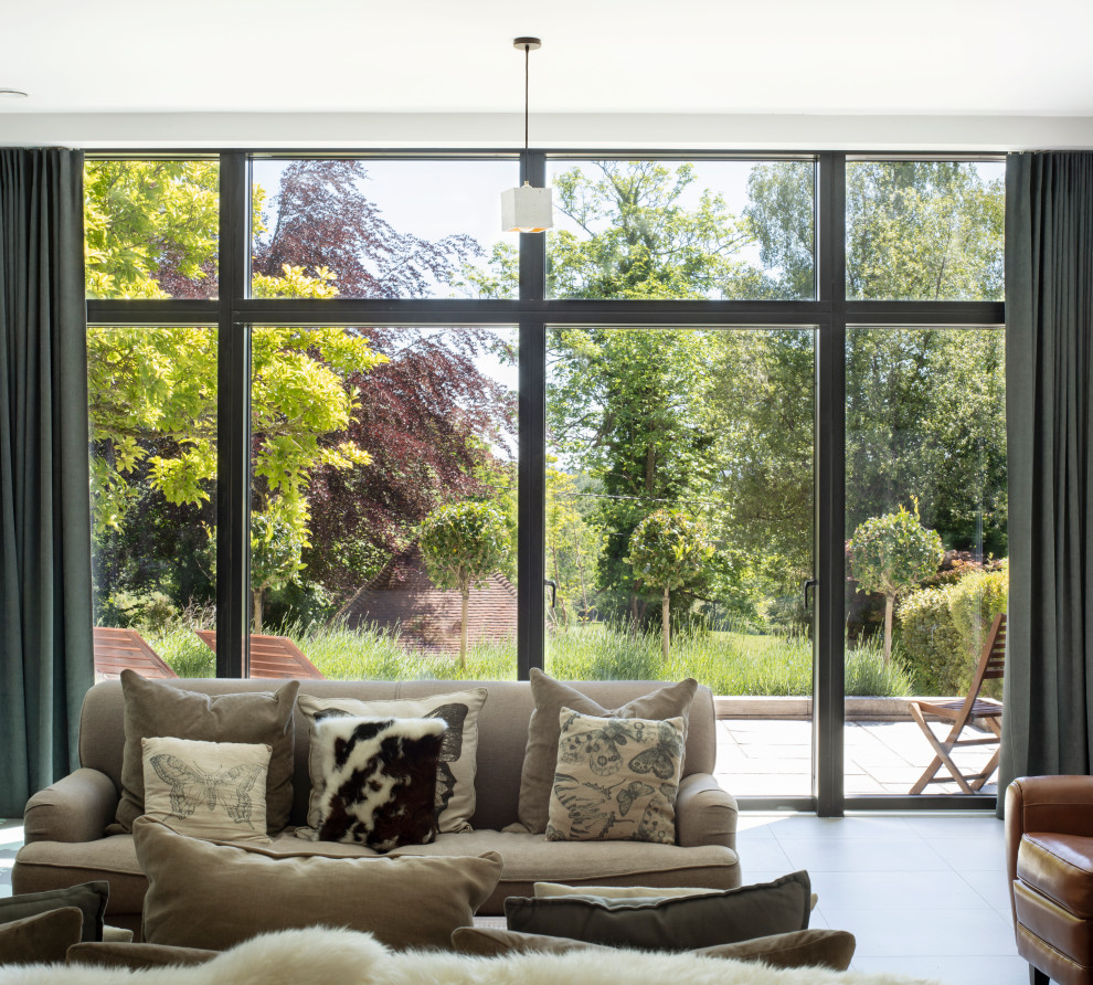 Inspiration for a contemporary enclosed living room in Hampshire with white walls, porcelain floors, a wood stove and grey floor.