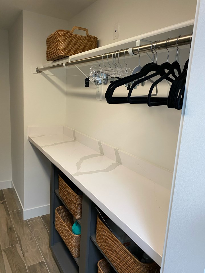 This is an example of a traditional galley utility room in Phoenix with an undermount sink, recessed-panel cabinets, grey cabinets, quartz benchtops, white walls, porcelain floors, a side-by-side washer and dryer, white floor and white benchtop.