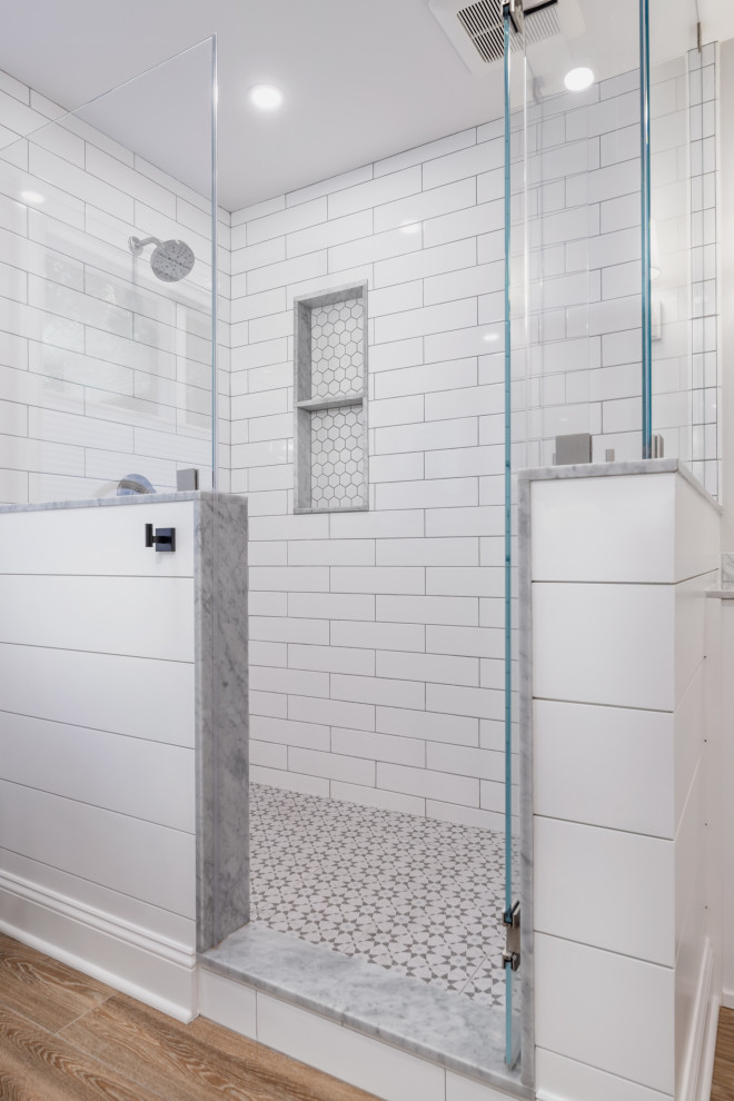 This is an example of a large country master bathroom in Boston with shaker cabinets, white cabinets, a freestanding tub, a corner shower, a one-piece toilet, white tile, subway tile, grey walls, porcelain floors, an undermount sink, marble benchtops, brown floor, a hinged shower door, multi-coloured benchtops, an enclosed toilet, a single vanity, a freestanding vanity and planked wall panelling.