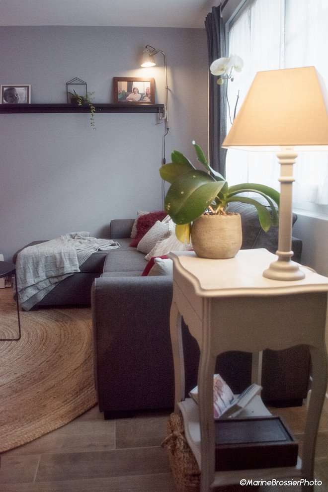 Aménagement d'un salon industriel ouvert avec un mur gris, parquet clair, aucune cheminée et aucun téléviseur.