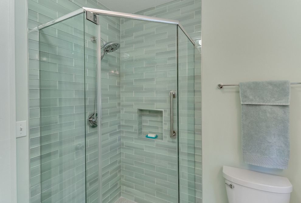 Mid-sized contemporary 3/4 bathroom in DC Metro with furniture-like cabinets, white cabinets, a corner shower, a two-piece toilet, gray tile, green tile, glass tile, green walls, an undermount sink, solid surface benchtops, beige floor and a hinged shower door.