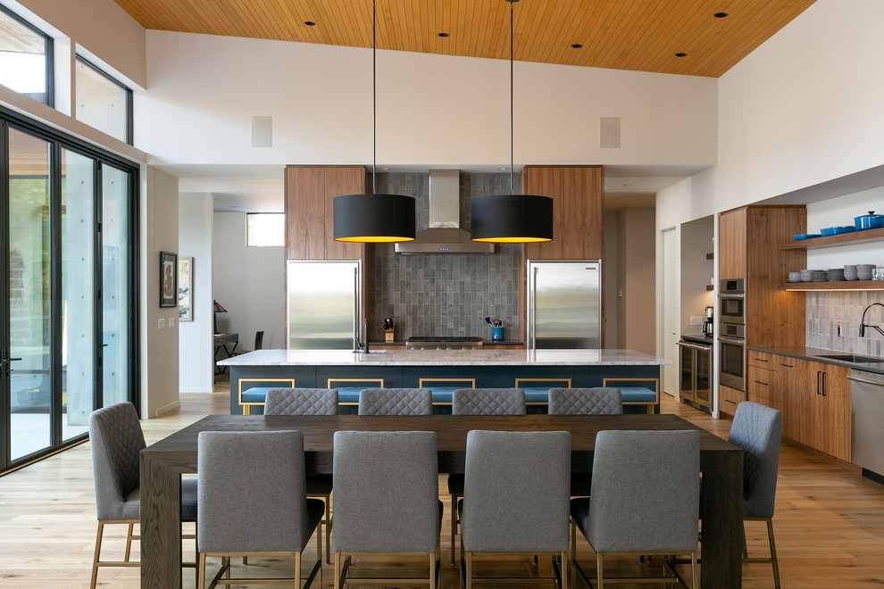 Photo of a large contemporary eat-in kitchen in Vancouver with flat-panel cabinets, medium wood cabinets, marble benchtops, grey splashback, ceramic splashback, stainless steel appliances, light hardwood floors, with island, grey benchtop, a single-bowl sink and beige floor.