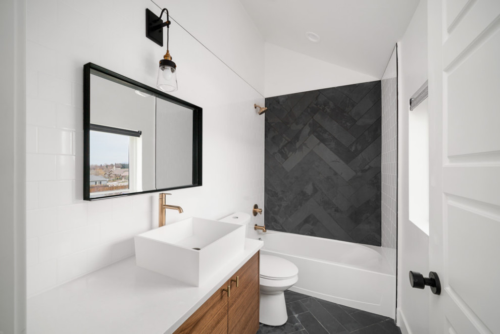 Inspiration for a modern bathroom in Denver with flat-panel cabinets, medium wood cabinets, a drop-in tub, a shower/bathtub combo, white tile, porcelain tile, white walls, ceramic floors, a vessel sink, quartzite benchtops, black floor, white benchtops, a single vanity and a floating vanity.