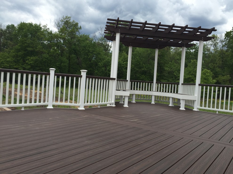 Mid-sized traditional backyard deck in New York with a pergola.