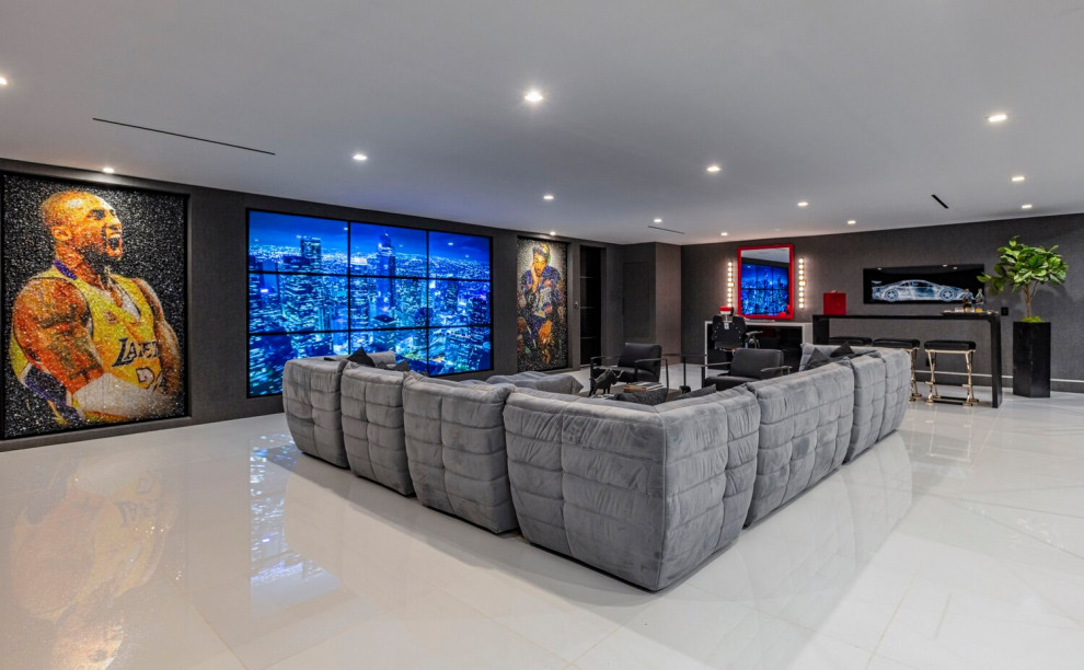Стильный дизайн: огромная открытая комната для игр в стиле модернизм с серыми стенами, телевизором на стене, белым полом и многоуровневым потолком без камина - последний тренд