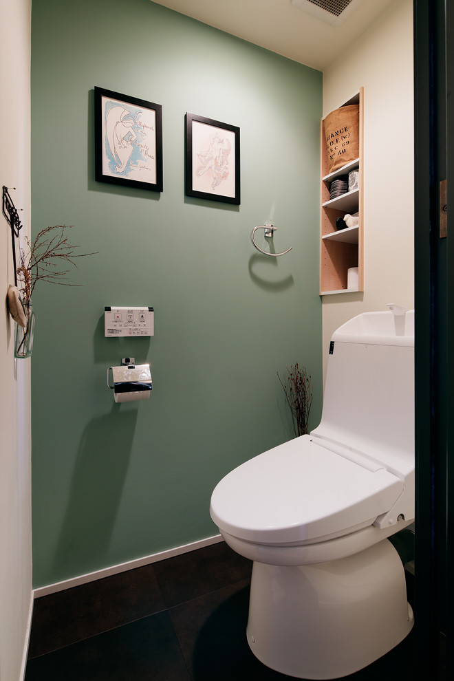 This is an example of an industrial powder room in Other with multi-coloured walls and black floor.
