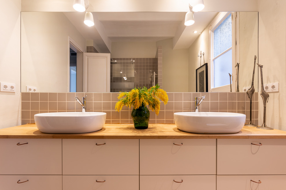 This is an example of a large contemporary master bathroom in Other with furniture-like cabinets, white cabinets, a corner shower, an urinal, beige walls, medium hardwood floors, a vessel sink, wood benchtops, brown floor, an open shower and brown benchtops.