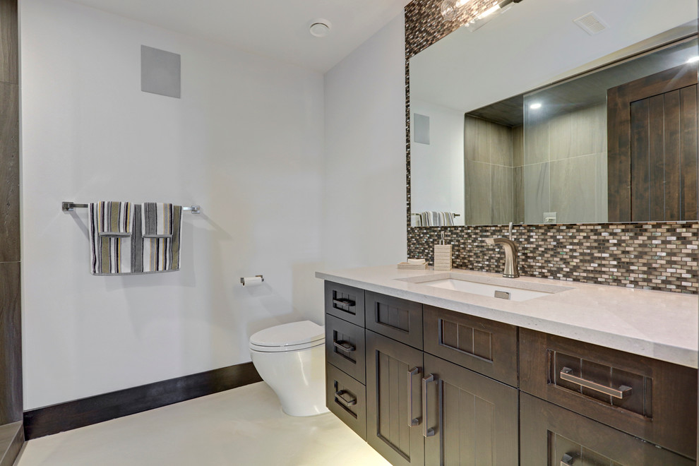 Mid-sized transitional 3/4 multicolored tile and mosaic tile concrete floor alcove shower photo in Calgary with shaker cabinets, dark wood cabinets, a one-piece toilet, white walls, an undermount sink and quartzite countertops