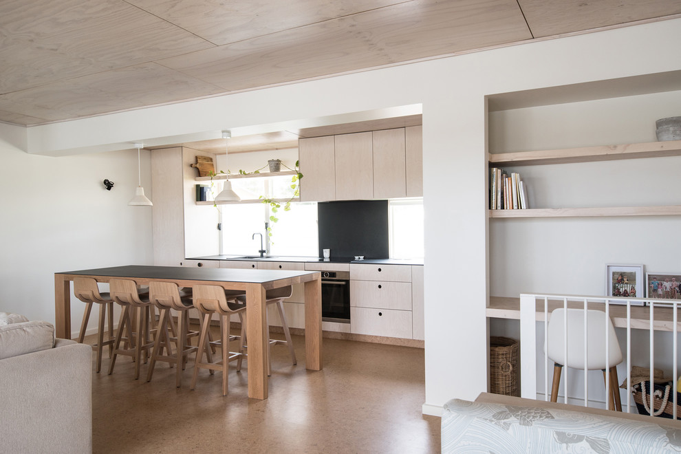 Beach style single-wall eat-in kitchen in Other with a double-bowl sink, tile benchtops, black splashback, porcelain splashback, stainless steel appliances, cork floors, with island, black benchtop and light wood cabinets.