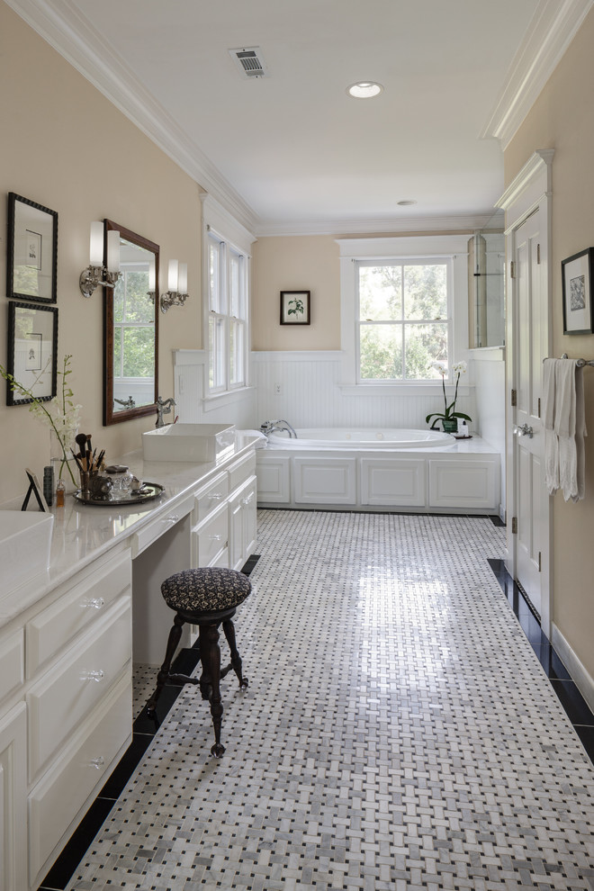 Design ideas for a large traditional master bathroom in Atlanta with raised-panel cabinets, white cabinets, a drop-in tub, a corner shower, a two-piece toilet, black and white tile, stone tile, beige walls, marble floors, a vessel sink and engineered quartz benchtops.