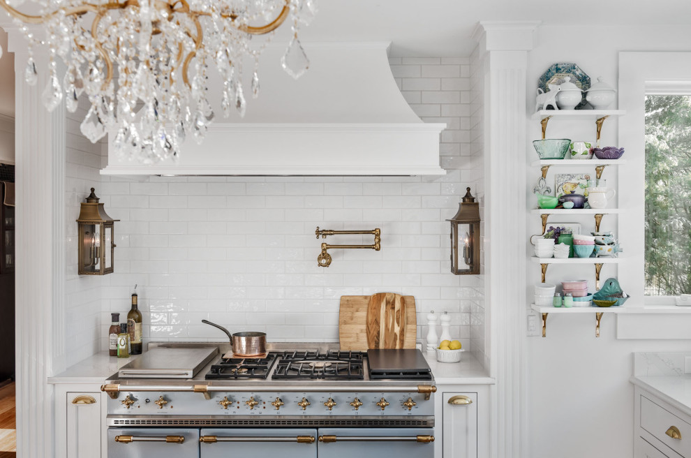 Design ideas for a mid-sized traditional galley kitchen in Portland Maine with a farmhouse sink, quartz benchtops, white splashback, porcelain splashback, light hardwood floors, with island and white benchtop.