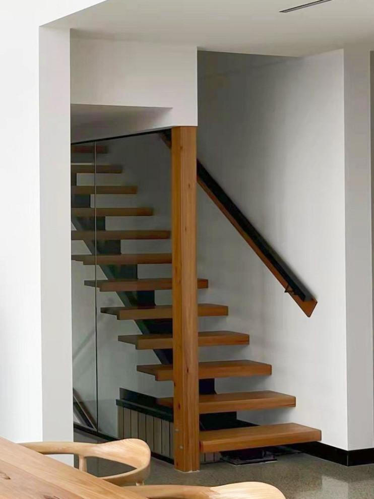 Design ideas for a mid-sized modern wood straight staircase in Melbourne with open risers, glass railing and wallpaper.