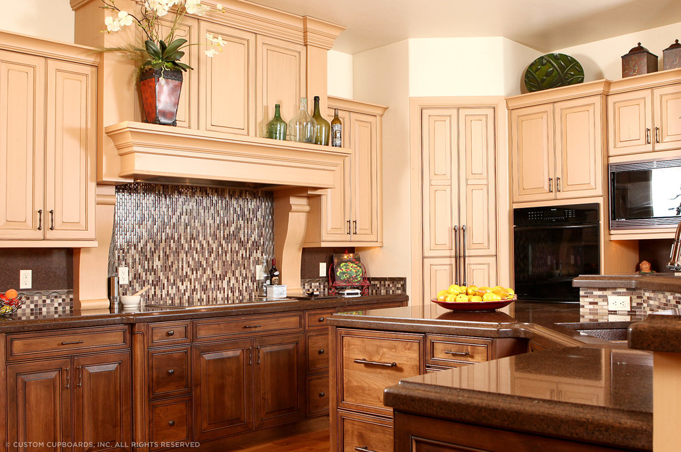 Mid-sized transitional l-shaped dark wood floor and brown floor enclosed kitchen photo in Albuquerque with raised-panel cabinets, medium tone wood cabinets, quartz countertops, multicolored backsplash, matchstick tile backsplash, black appliances and an island