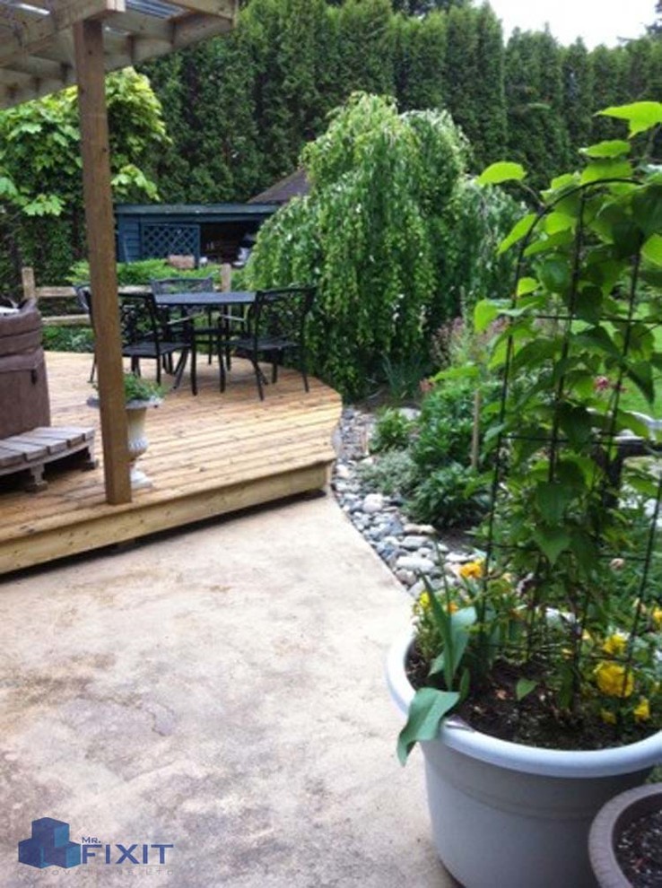This is an example of a small country backyard patio in Vancouver with concrete slab and a roof extension.