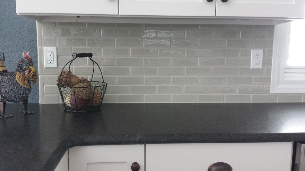 Example of a large transitional kitchen design with white cabinets, granite countertops, gray backsplash, ceramic backsplash and gray walls