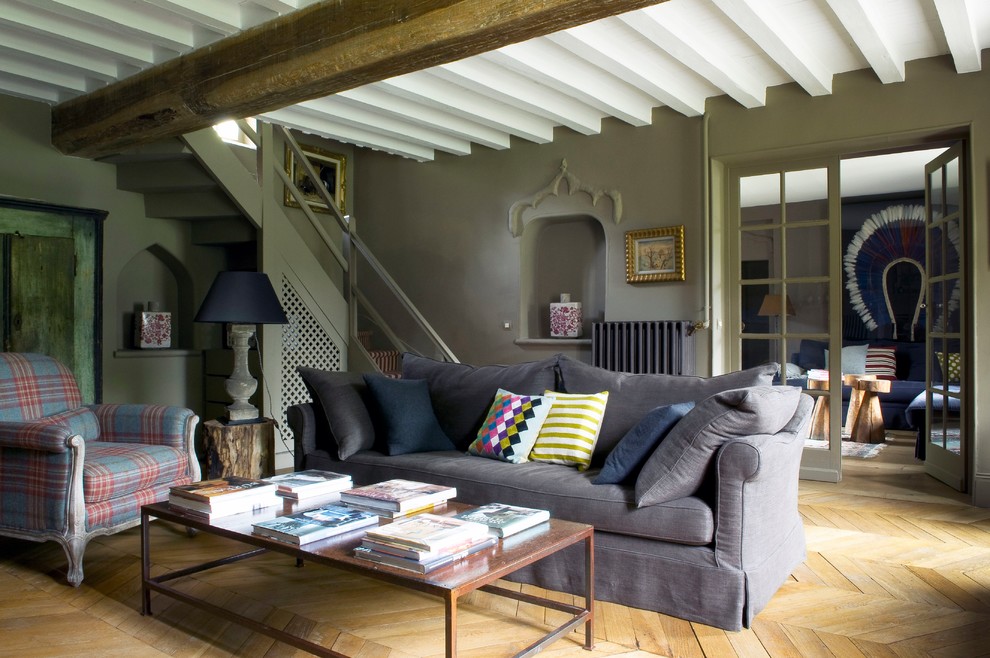 Idée de décoration pour une salle de séjour design de taille moyenne et fermée avec un mur gris, parquet clair, une cheminée standard, un manteau de cheminée en brique, aucun téléviseur et un sol marron.