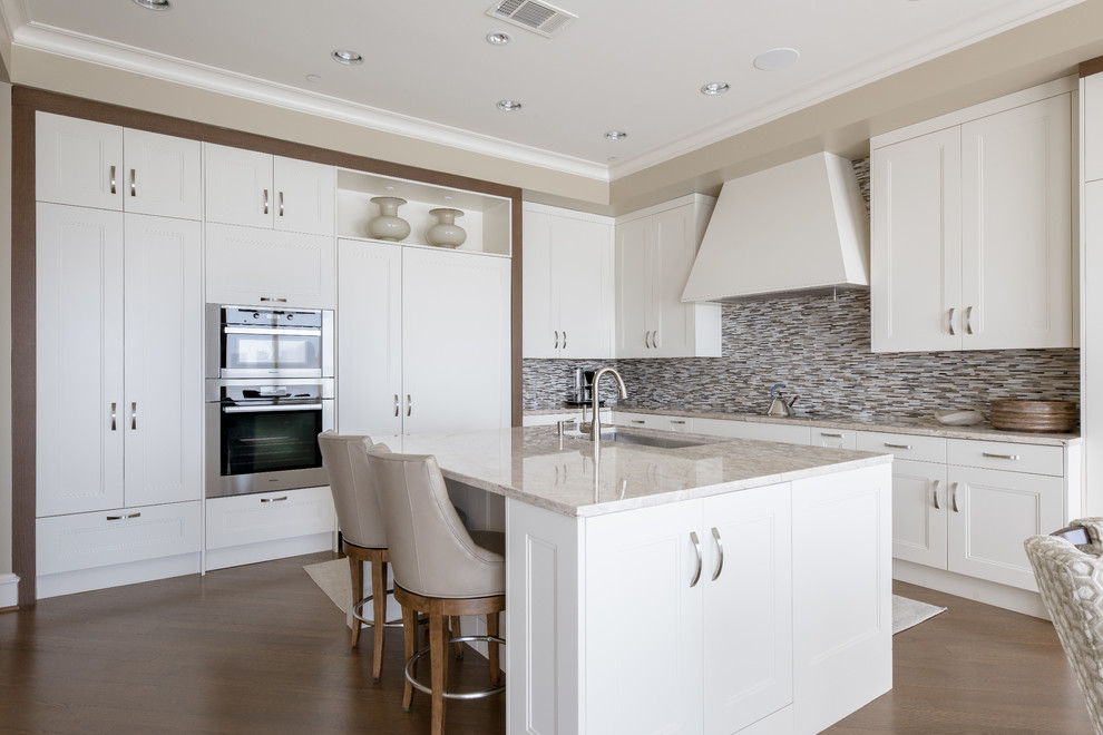Inspiration for a large transitional l-shaped kitchen in Dallas with an undermount sink, white cabinets, quartzite benchtops, stainless steel appliances, with island, recessed-panel cabinets, multi-coloured splashback, matchstick tile splashback and medium hardwood floors.