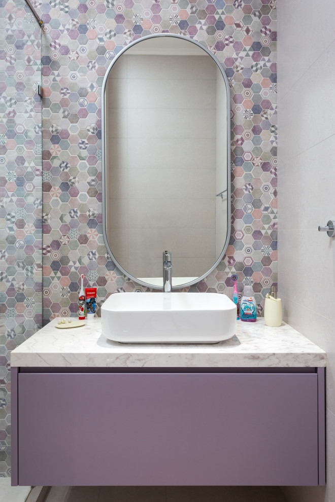 Photo of a mid-sized contemporary powder room in Other with flat-panel cabinets, purple cabinets, mosaic tile, white walls, a vessel sink and white benchtops.