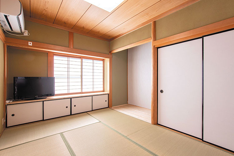 Cette image montre une salle de séjour asiatique fermée avec un mur vert, un sol de tatami, aucune cheminée, un téléviseur indépendant, un sol vert et un plafond en bois.