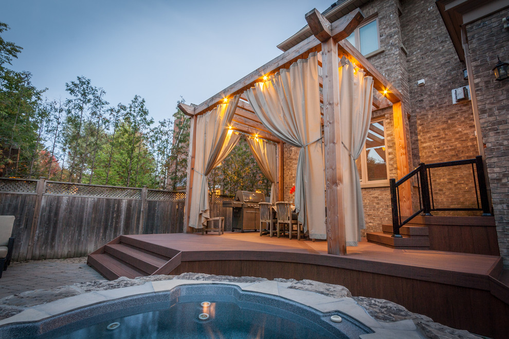 Inspiration for a mid-sized transitional backyard deck remodel in Toronto with a pergola
