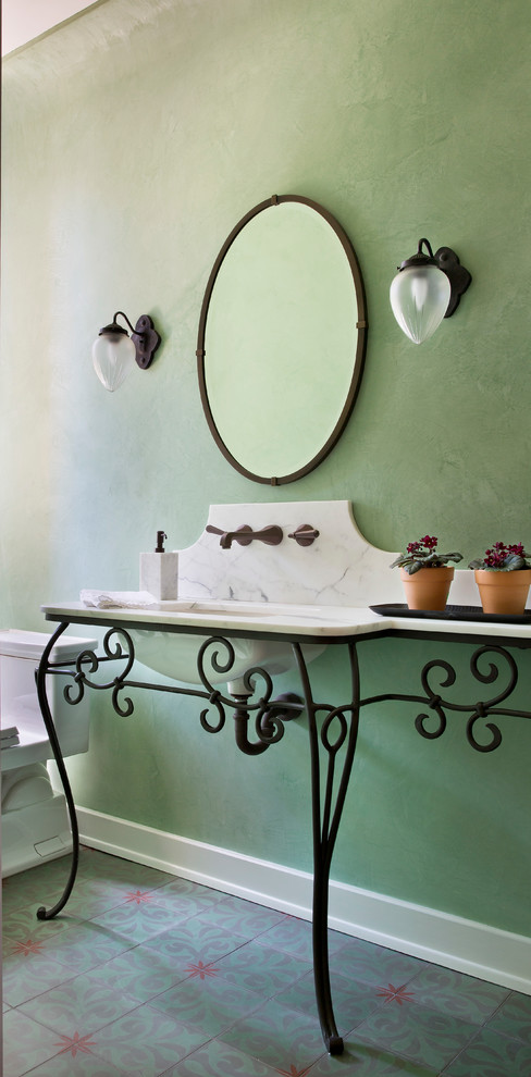 Mediterranean powder room in Los Angeles with a console sink, green walls and white benchtops.
