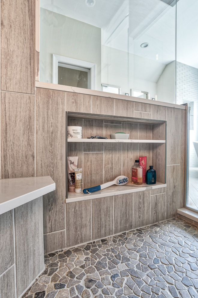 Expansive transitional master bathroom in New York with shaker cabinets, dark wood cabinets, a freestanding tub, an alcove shower, gray tile, glass tile, beige walls, an undermount sink, engineered quartz benchtops, a hinged shower door and white benchtops.