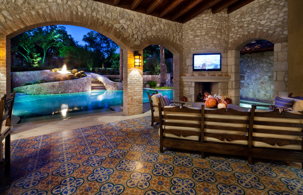 Inspiration for a large mediterranean backyard patio in Austin with a fire feature, a roof extension and tile.