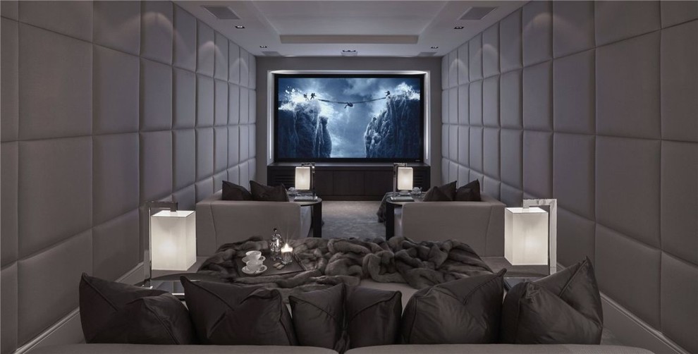 Expansive contemporary enclosed home theatre in Gloucestershire with carpet, a projector screen and grey walls.