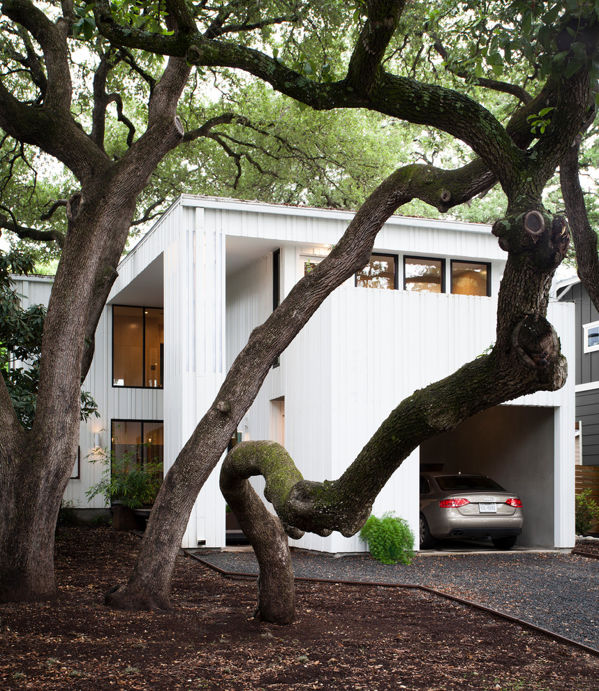 Design ideas for a large contemporary two-storey white house exterior in Austin with wood siding and a flat roof.