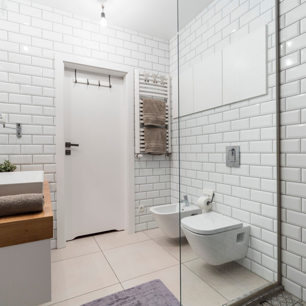 Photo of a small modern shower room bathroom in New York with freestanding cabinets, white cabinets, a walk-in shower, a bidet, white tiles, metro tiles, white walls, ceramic flooring, a vessel sink, engineered stone worktops, beige floors, a hinged door, white worktops, a single sink and a floating vanity unit.