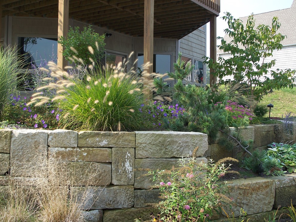 Inspiration for a mid-sized eclectic backyard partial sun garden for summer in Cleveland with a retaining wall.