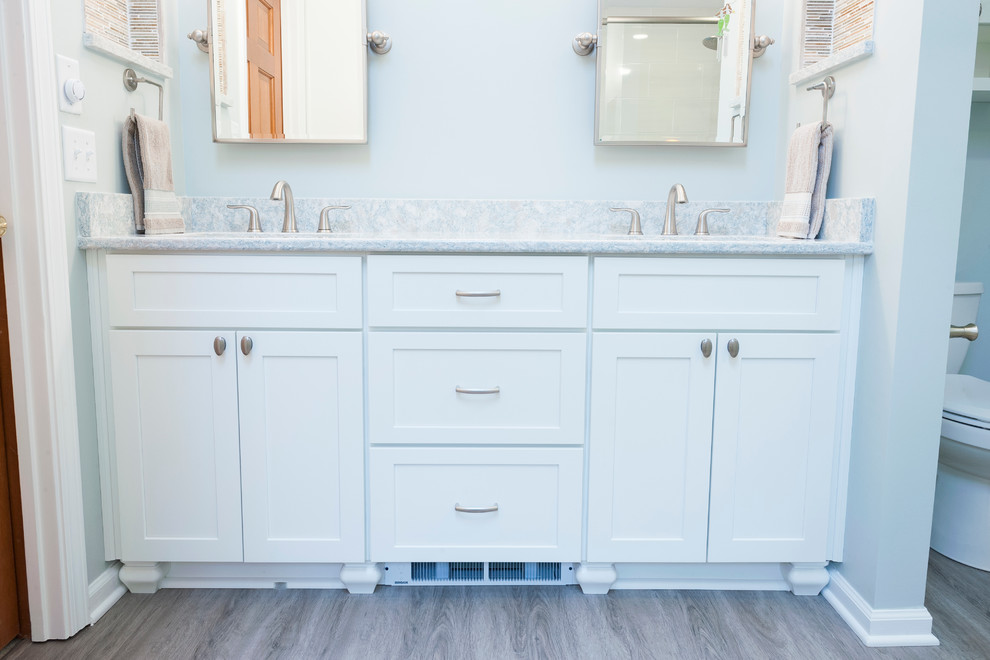 Design ideas for a mid-sized transitional master bathroom in Indianapolis with an undermount sink, shaker cabinets, white cabinets, quartzite benchtops, a corner shower, white tile, ceramic tile, blue walls and vinyl floors.