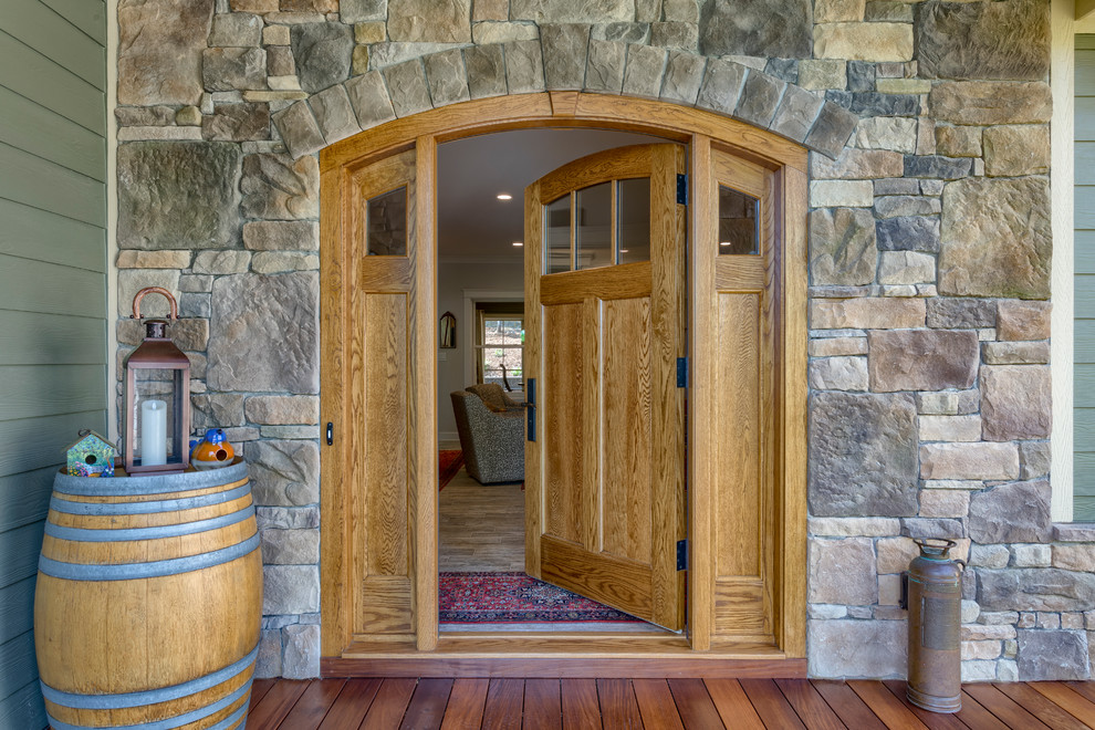 This is an example of a mid-sized arts and crafts front door in Other with brown walls, medium hardwood floors, a single front door, a medium wood front door and brown floor.