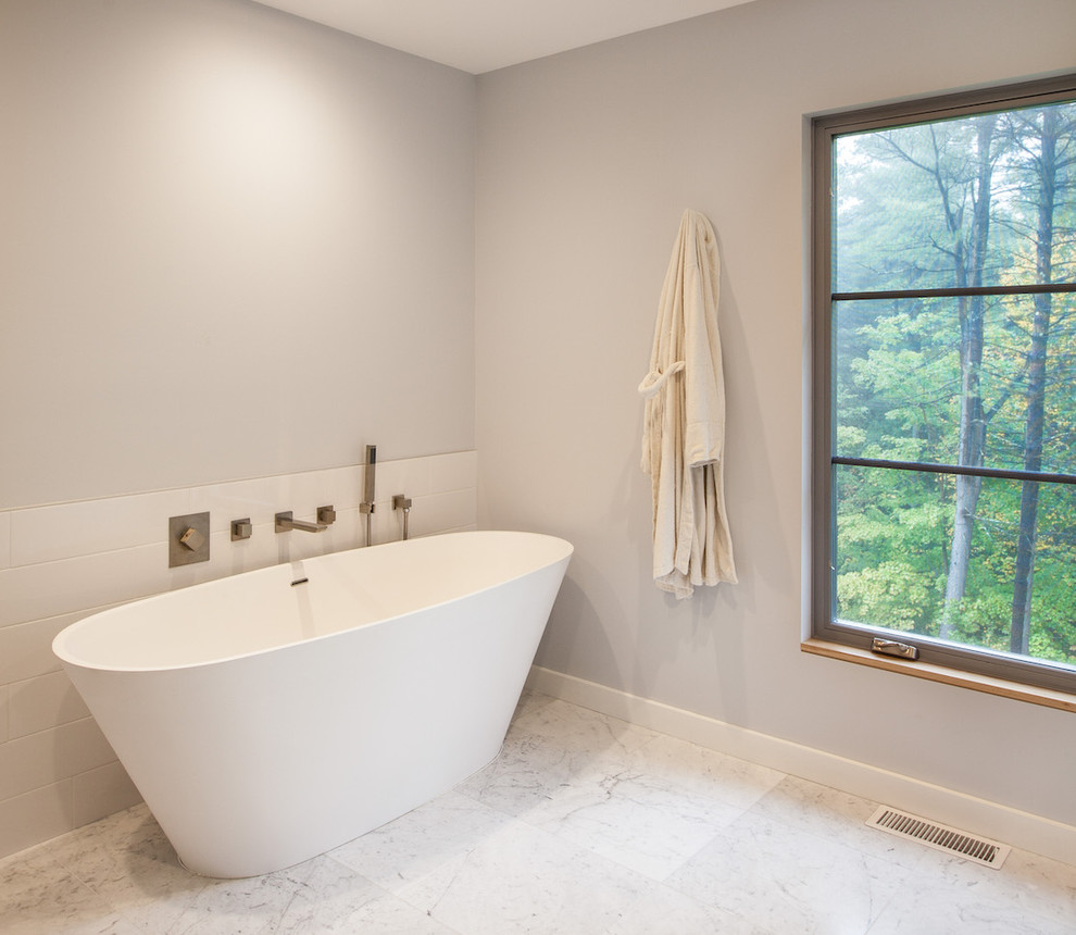 Inspiration for a mid-sized modern master bathroom in Burlington with flat-panel cabinets, grey cabinets, a freestanding tub, a corner shower, gray tile, porcelain tile, grey walls, marble floors, an undermount sink, engineered quartz benchtops, grey floor, a hinged shower door and white benchtops.