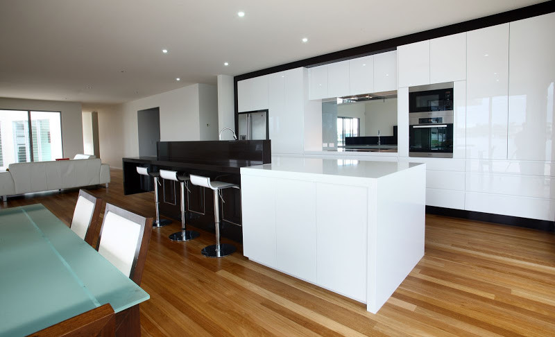 Inspiration for a large modern kitchen in Sunshine Coast with flat-panel cabinets, white cabinets, stainless steel appliances, medium hardwood floors and with island.