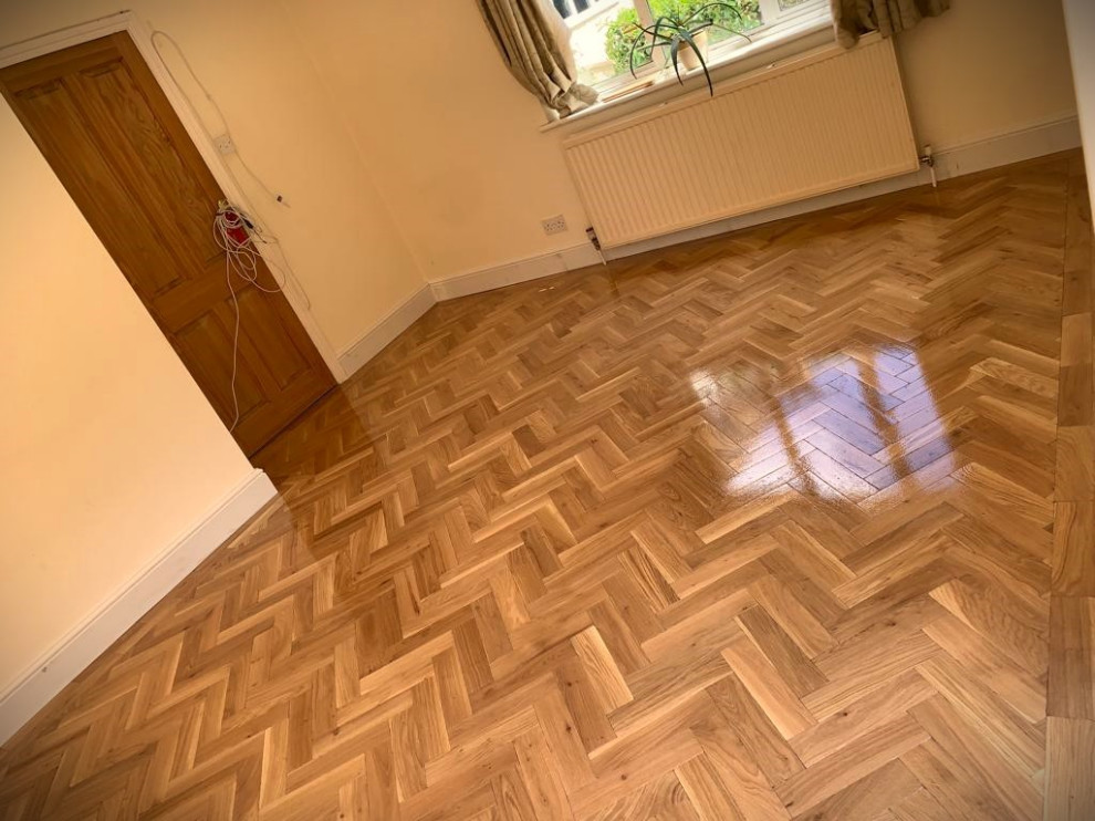 Example of a mid-sized classic medium tone wood floor and brown floor enclosed dining room design in Hertfordshire with white walls