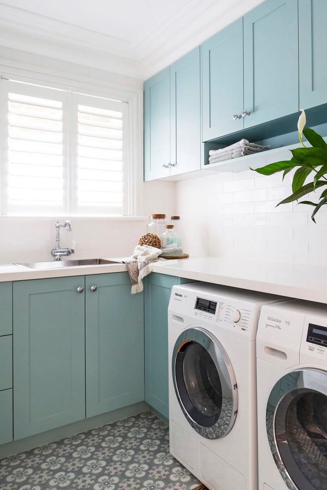 Inspiration for a traditional laundry room in Sydney with shaker cabinets, green cabinets, solid surface benchtops, white walls, porcelain floors, a side-by-side washer and dryer and white benchtop.