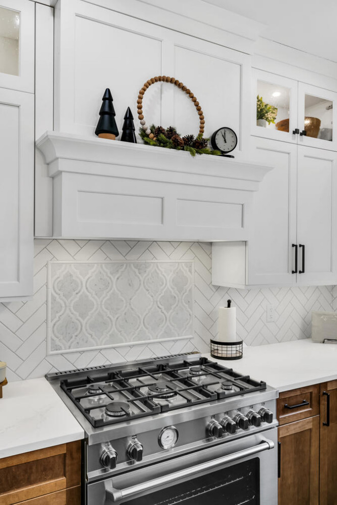 Design ideas for a mid-sized transitional l-shaped eat-in kitchen in New York with an undermount sink, flat-panel cabinets, white cabinets, quartz benchtops, white splashback, ceramic splashback, stainless steel appliances, porcelain floors, black floor and white benchtop.