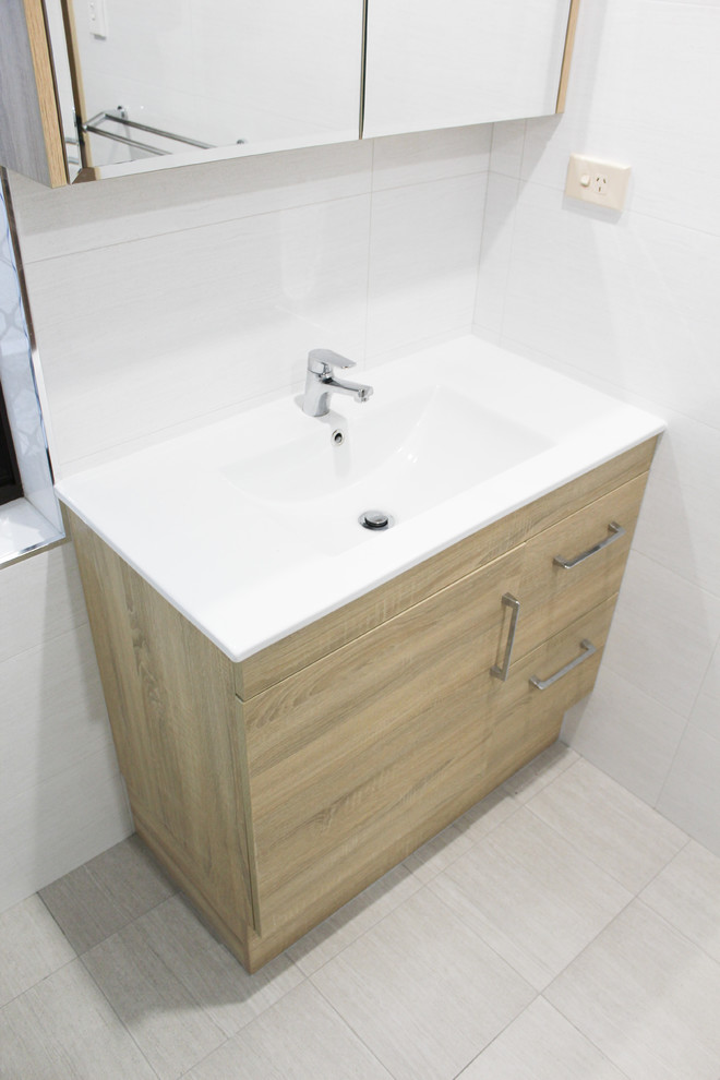 Inspiration for a large modern master bathroom in Perth with furniture-like cabinets, light wood cabinets, an open shower, gray tile, ceramic tile, grey walls, porcelain floors, an integrated sink, solid surface benchtops, grey floor, an open shower and white benchtops.