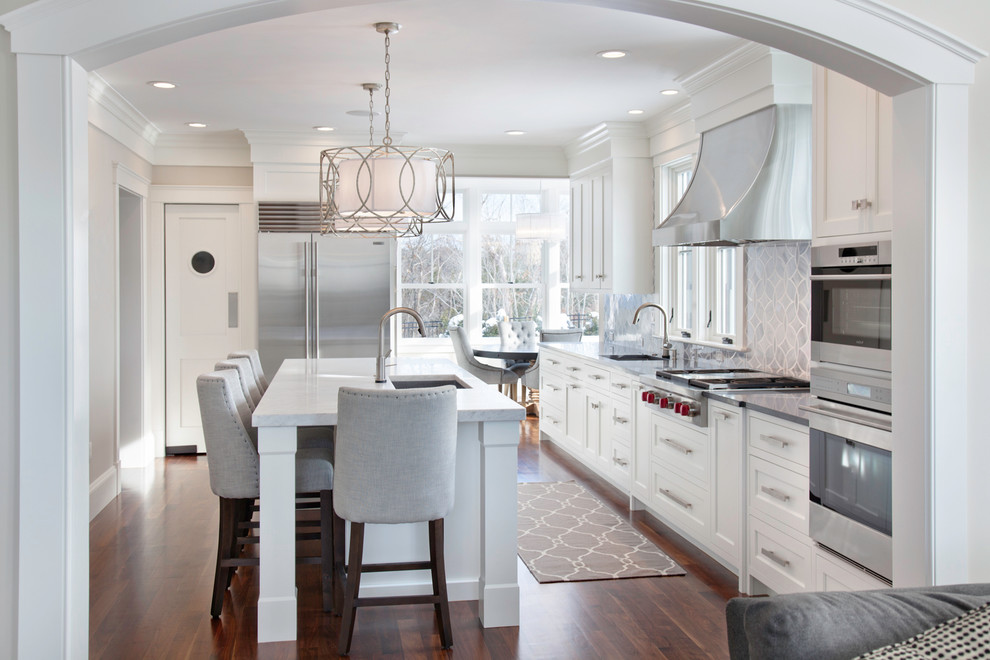Open concept kitchen - transitional l-shaped open concept kitchen idea in Boston with an undermount sink, shaker cabinets, white cabinets, gray backsplash and stainless steel appliances