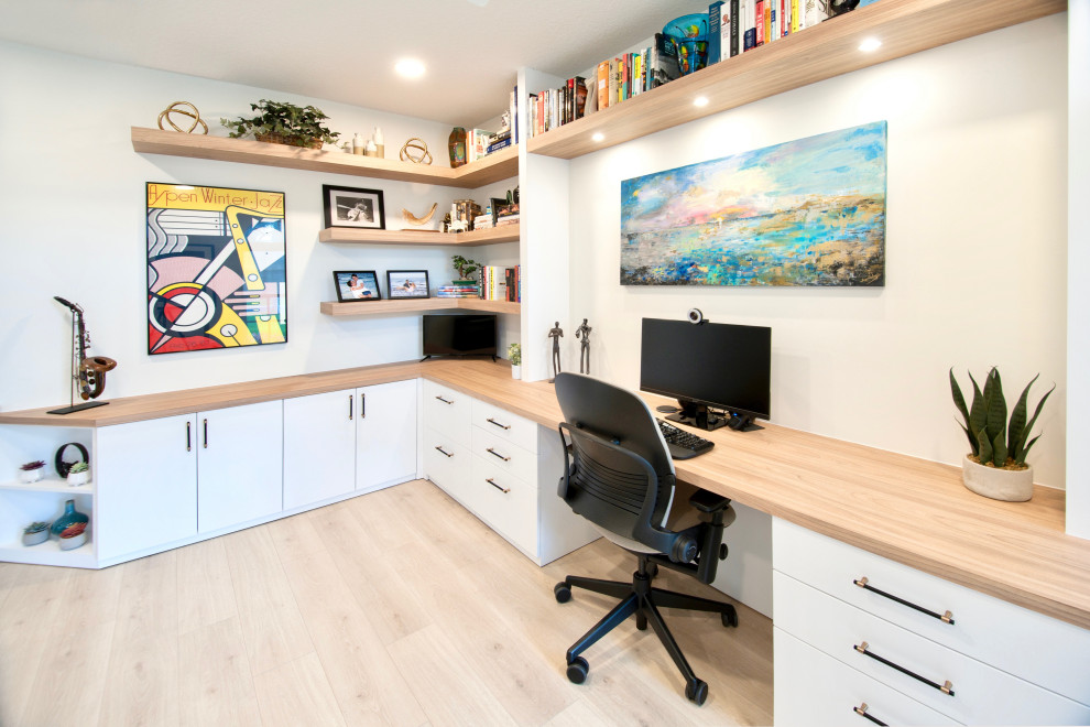 Aménagement d'un grand bureau bord de mer avec un mur blanc, sol en stratifié, un bureau intégré et un sol beige.