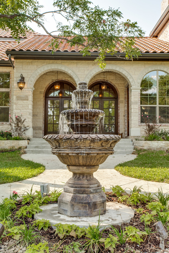 Photo of a large mediterranean front yard full sun garden in Austin with a water feature.