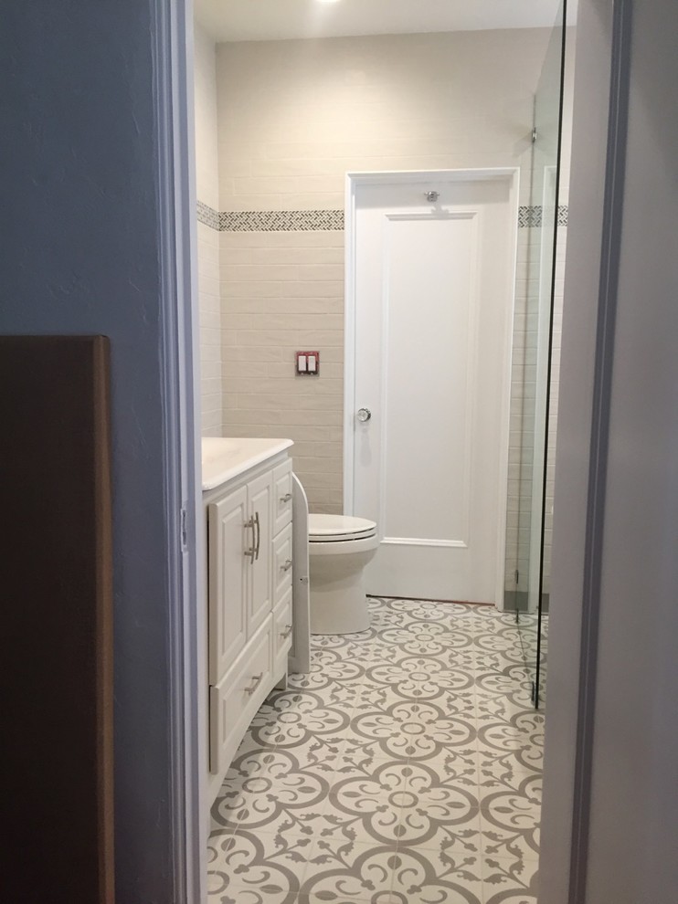 This is an example of a mid-sized mediterranean 3/4 bathroom in Los Angeles with furniture-like cabinets, white cabinets, a claw-foot tub, a shower/bathtub combo, a one-piece toilet, gray tile, subway tile, grey walls, cement tiles, an integrated sink, tile benchtops, grey floor and an open shower.