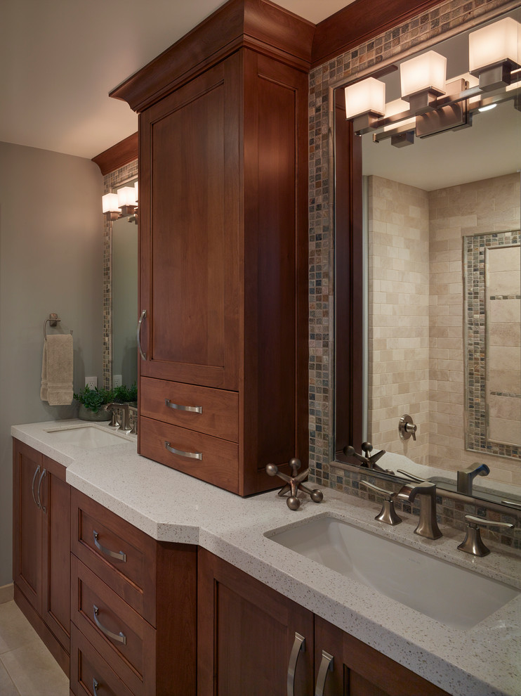 This is an example of a mid-sized traditional bathroom in San Francisco with recessed-panel cabinets, medium wood cabinets, an undermount tub, a double shower, a one-piece toilet, gray tile, mosaic tile, grey walls, porcelain floors, an undermount sink, engineered quartz benchtops and grey benchtops.