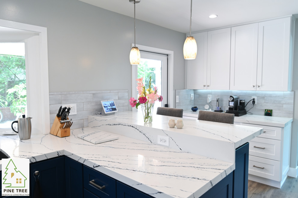 Photo of a large modern u-shaped eat-in kitchen in Los Angeles with shaker cabinets, blue cabinets, marble benchtops, grey splashback, ceramic splashback, stainless steel appliances, a peninsula and white benchtop.
