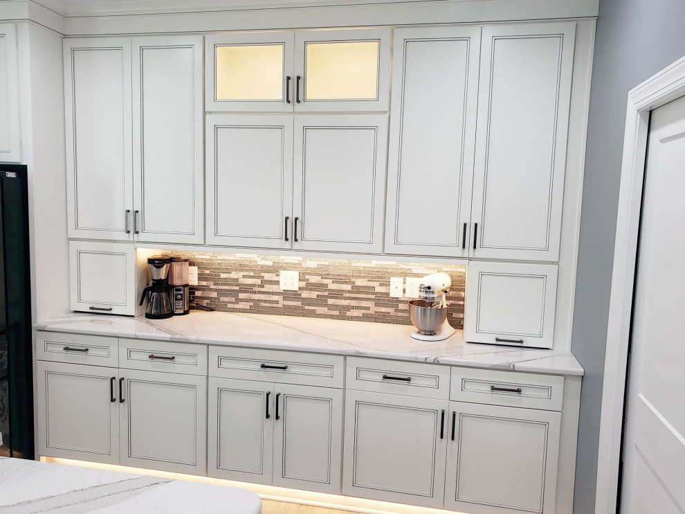 Eat-in kitchen - transitional u-shaped eat-in kitchen idea with recessed-panel cabinets, white cabinets, quartz countertops, multicolored backsplash, mosaic tile backsplash, two islands and white countertops