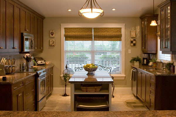 Inspiration for a porcelain tile kitchen remodel with a farmhouse sink, raised-panel cabinets, dark wood cabinets, granite countertops, multicolored backsplash, ceramic backsplash, stainless steel appliances and an island