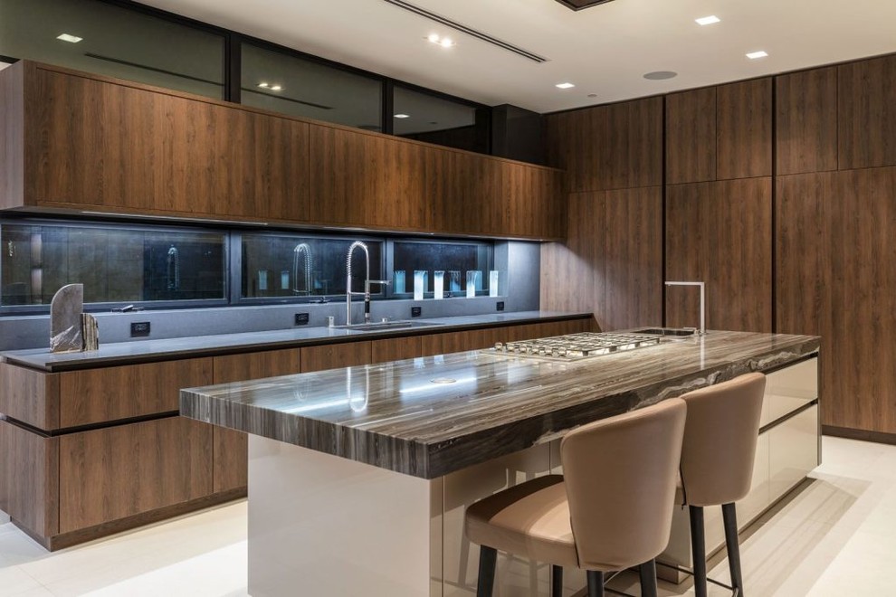 This is an example of a large modern single-wall open plan kitchen with flat-panel cabinets, medium wood cabinets, marble benchtops, ceramic floors, with island and grey floor.