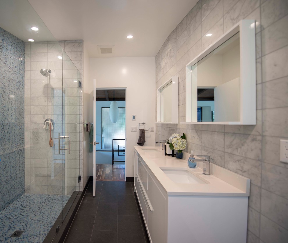 Design ideas for a mid-sized modern master bathroom in Other with furniture-like cabinets, white cabinets, a corner shower, a two-piece toilet, white tile, glass sheet wall, white walls, porcelain floors, an integrated sink, quartzite benchtops, black floor, a hinged shower door and white benchtops.